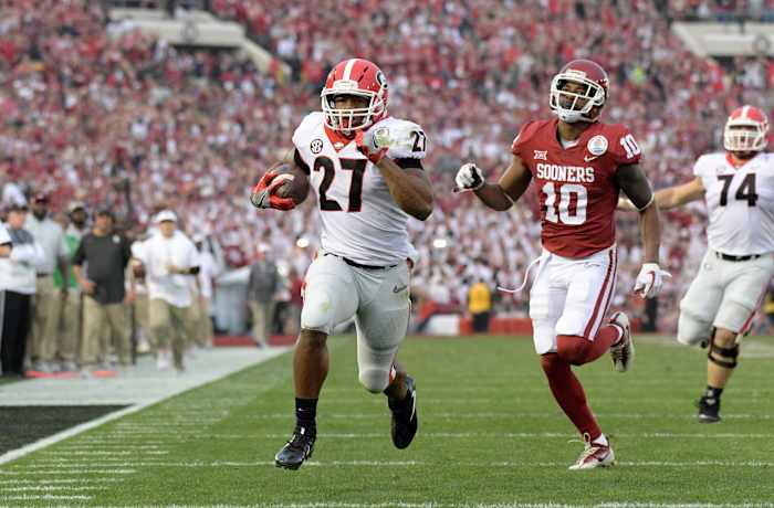 Jan 1, 2018; Pasadena, CA, USA; Georgia Bulldogs running back Nick Chubb (27) is pursued by Oklahoma Sooners defensive back Steven Parker (10) on a 50-yard touchdown run in the third quarter in the 2018 Rose Bowl college football playoff semifinal game at Rose Bowl Stadium. Georgia defeated Oklahoma 54-48 in two overtimes.
